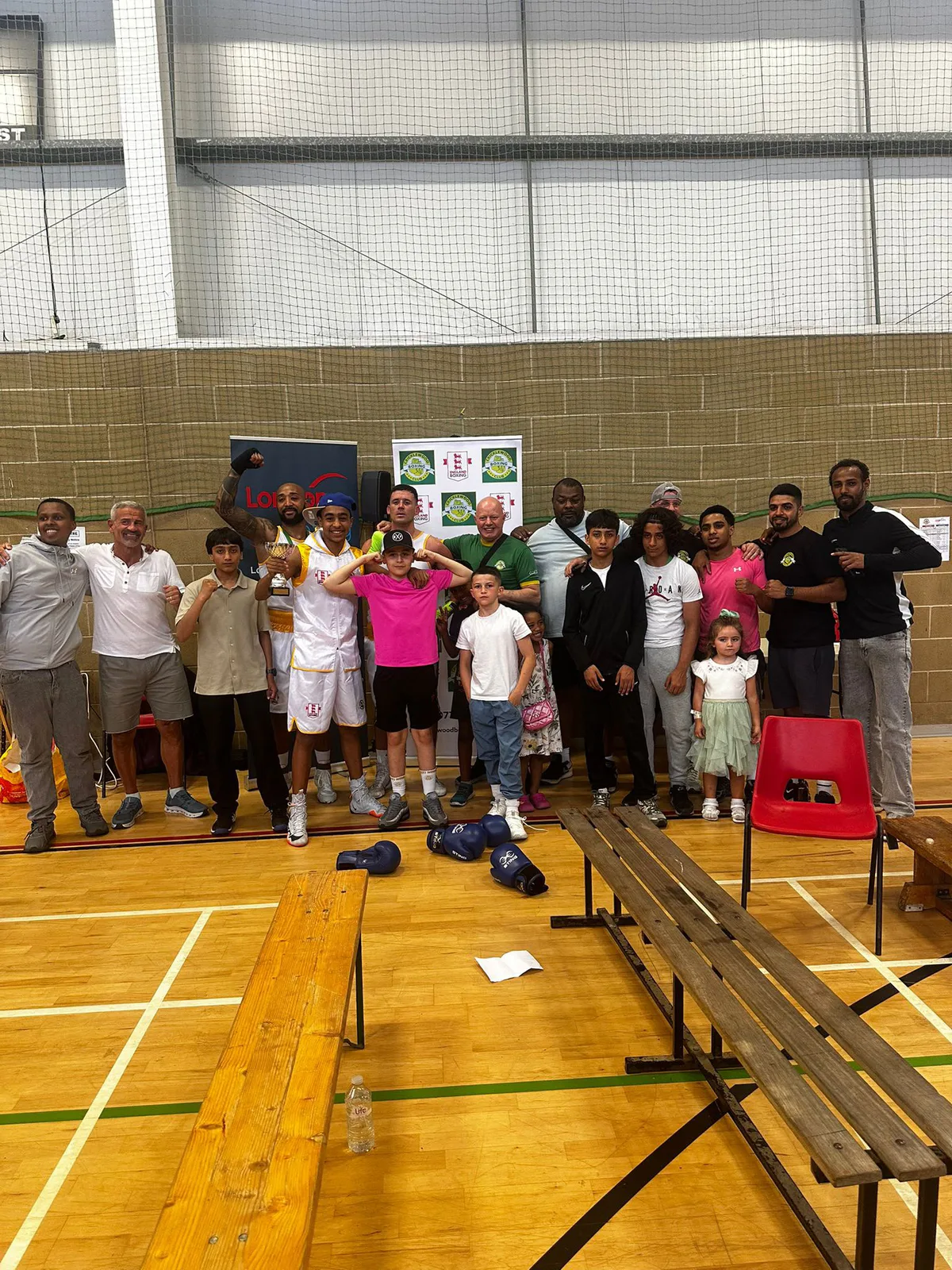 The Cricklewood Boxing Club team, friends and families celebrating with a trophy
