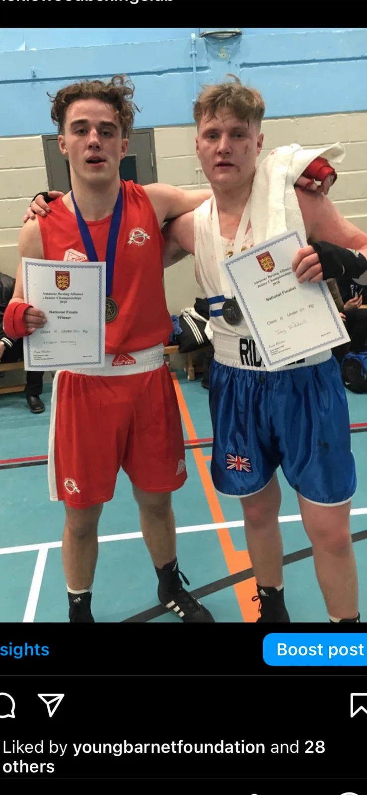 Two amateur boxers displaying their national championship certificates and medals