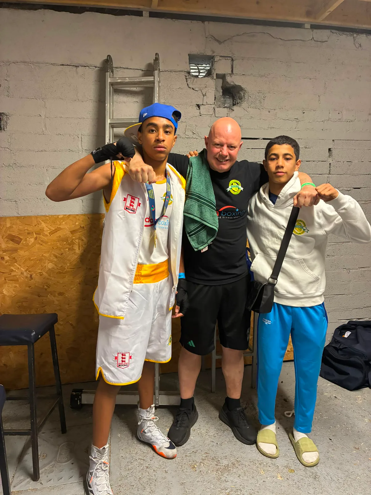 Two young boxers and their coach together backstage